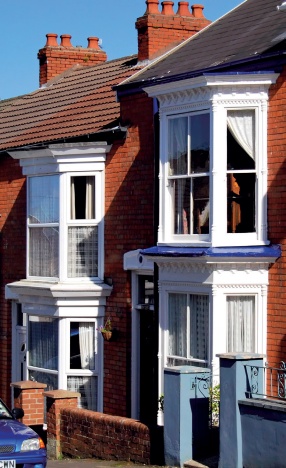 Neighbouring terraced houses, one with modern UPVC windows, the other with timber sash windows