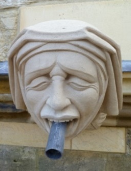New gargoyle depicting woman wearing wimple and with rainwater spout passing through mouth