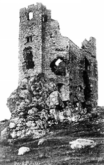 B'w photo showing the ruined castle before 1900 with gaping holes in the exterior walls and no roofing