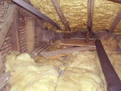 Loft space with spray foam insulation between rafters and glass fibre insulation between ceiling joists