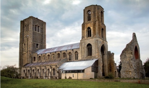 The exterior of Wymondham Abbey with modern extension and ruined octagonal tower and east end