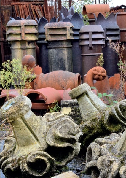 Chimney pots, roof tiles and terracotta finials in an architectural salvage yard
