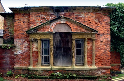 Severely decayed sandstone elements in red brick elevation
