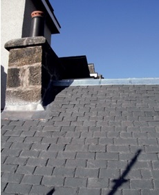Completed new slate roof with lead chimney flashing and ridge roll