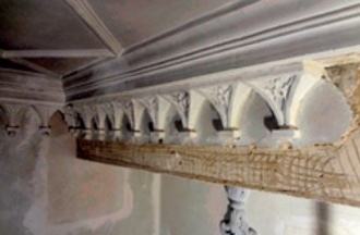 The same beam as in the previous illustration, partially refinished and with a run of its decorative arch-shaped pendentives now reinstated