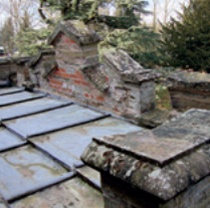 Crenellated parapet in brick and stone, which is leaning inwards over stepped lead sheet roof of north transept