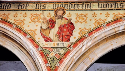 Spandrel decoration depicting St Mark with repeated winged lion stencils forming background and English text above
