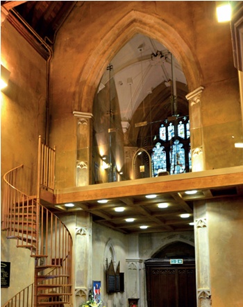 Modern bell-ringing platform in a historic church, accessed by spiral staircase and with sheet glass balustrade leaving unobstructed view of historic fabric