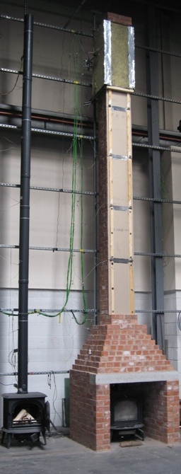 Pair of test rigs in an industrial building; one with an unenclosed flue and one with a brick chimney