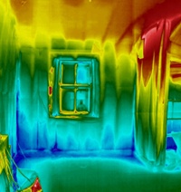 Thermal image of room interior with blue cold patch at wall/floor junctions and in lower corners