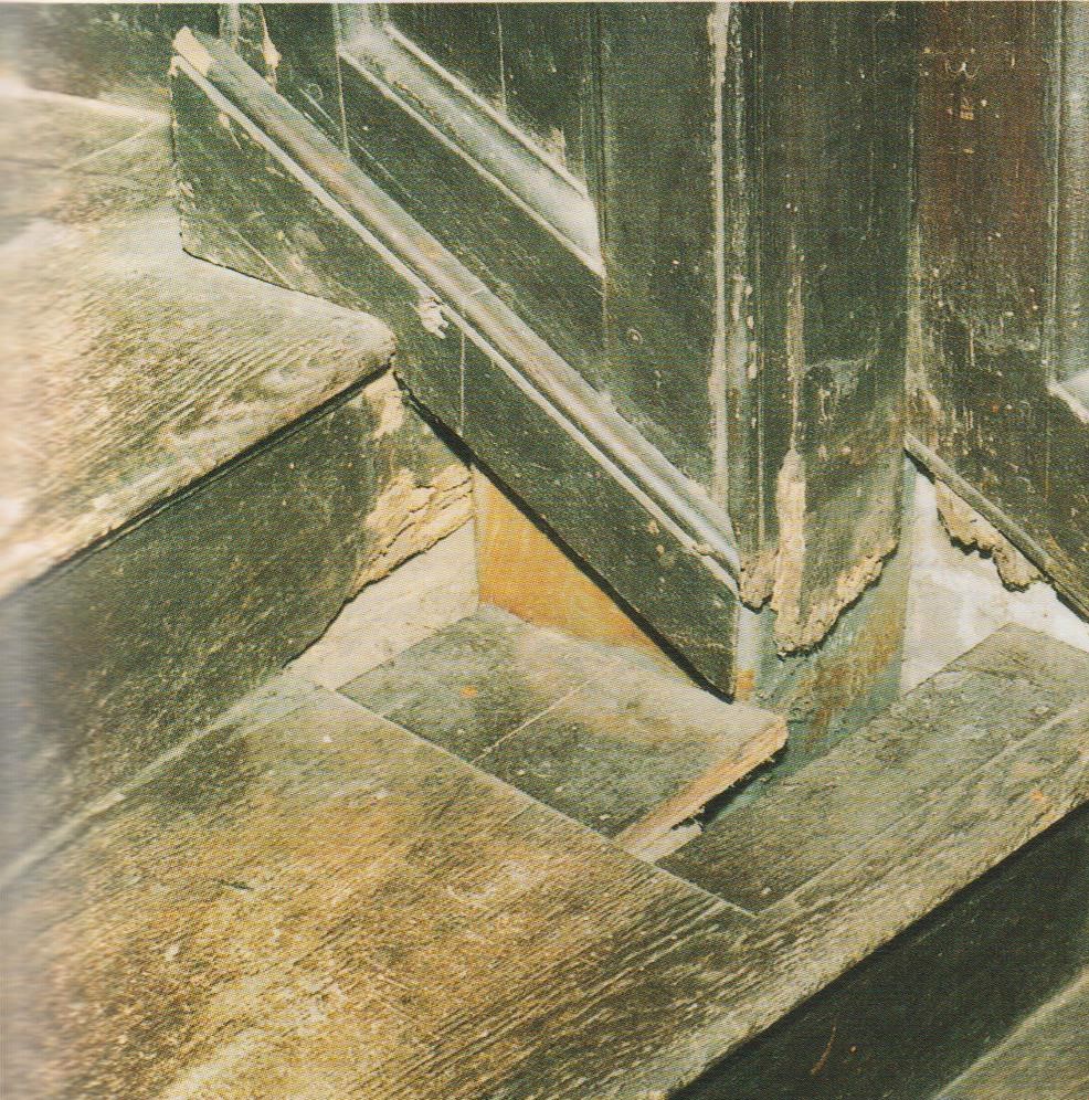 Dangerous-looking damage to the bottom step and side panel of a timber staircase