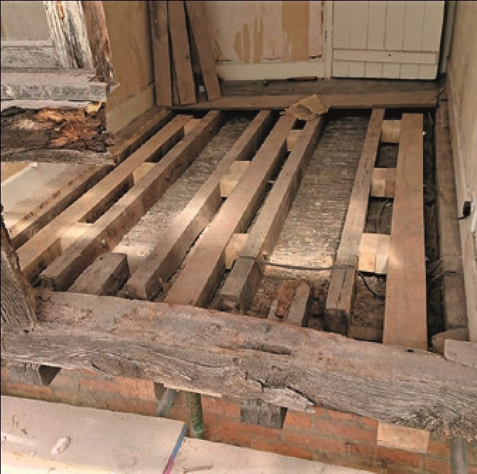 A dismantled timber frame with new jetty joists bolted in
