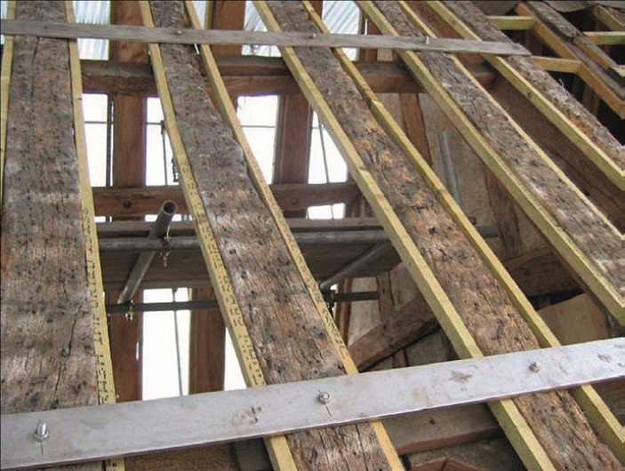 Steel plates to strengthen rafters are placed over the back of the rafters and bolted
