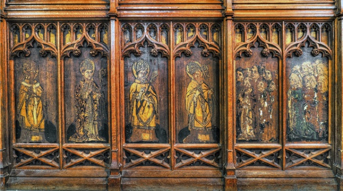 Timber screen painted with figures of episcopal saints and lay donors