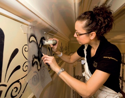 A trainee applies stencilled decoration 