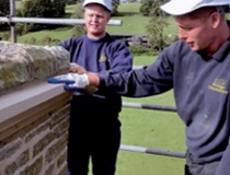 A trainee and a stonemason admire a recently completed stone repair