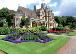 Tyntesfield's High Victorian Gothic exterior, with gardens in bloom in the foreground