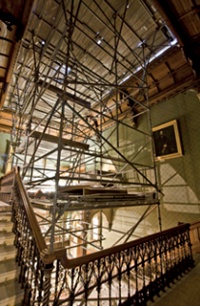 A vast and complex scaffolding array occupies the main stairwell