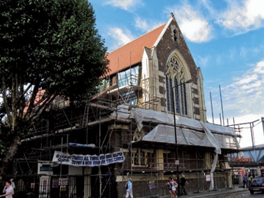 The scaffolded exterior of St Michael's, bounded by a busy Camden street