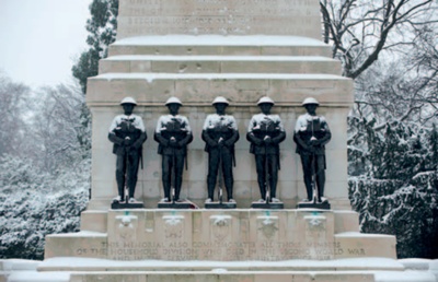 Five snow-capped bronze soldiers stand watch at The Guards Memorial, London