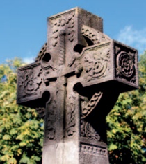 Stone wheel-cross memorial adorned with sword and foliage designs
