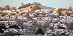 A photograph of a cluster of snow-topped houses