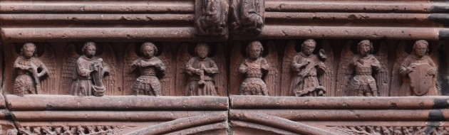 Angels playing mediaevel musical instruments in a carving over a doorway at Chester Cathedral 